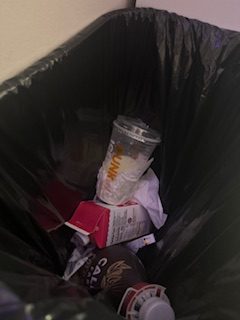 Dunkin' cup in a trash can.